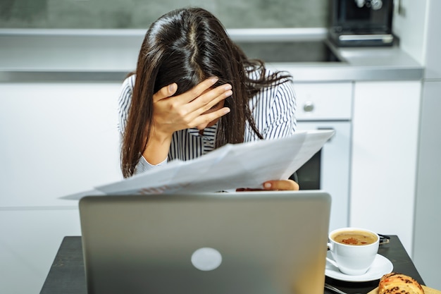 Wzburzeni Biznesowej Kobiety Mienia Dokumenty Pracuje Na Laptopie W Domu.