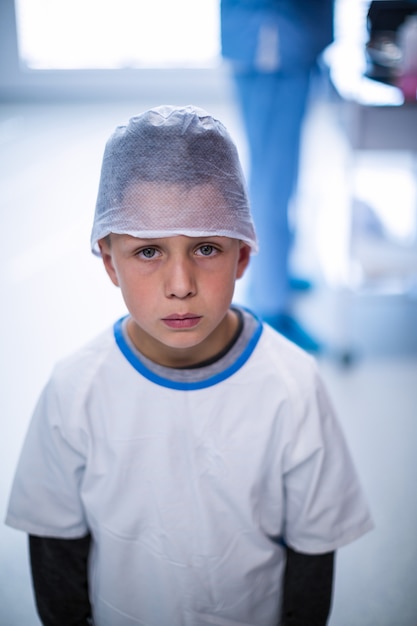 Wzburzona chłopiec w chirurgicznie nakrętce przy szpitalem