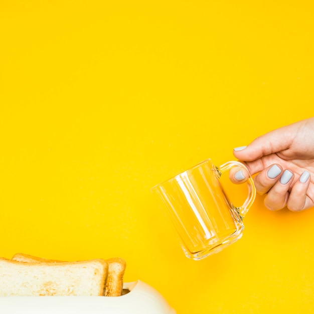 Wznoszący toast chleb wtyka z tostera na żółtym tle