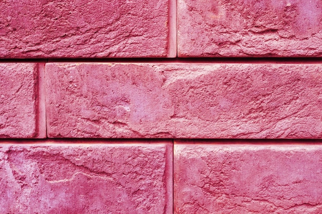 Wzór dekoracyjnej, różowej powierzchni kamiennej łupka jako tło stonowane w kolorze trendu viva magenta roku 2023
