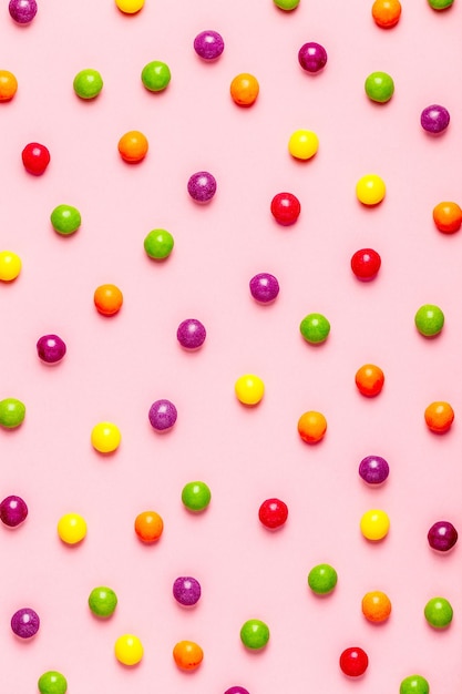 Wzór kolorowe cukierki na różowym tle