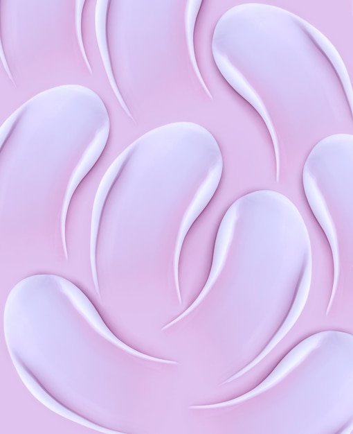 Wzór kosmetyczny rozmazuje kremową teksturę na pastelowym różowym tle