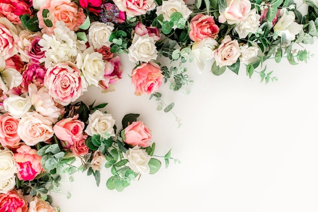 Zdjęcie wzór kwiatowy wykonany z różowych beżowych róż pąków kwiatowych na białym tle płaski widok z góry