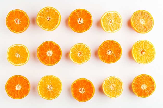 Wzór pomarańczowy i żółty mandarynki przeciąć na pół na białym