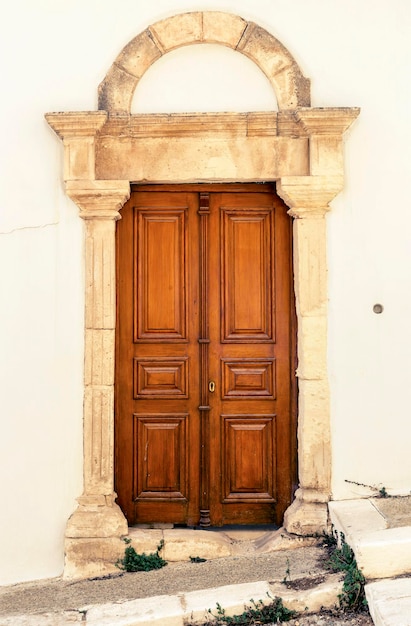 Wzór tekstury Tło stara beżowa ściana wykonana z naturalnego kamienia z drzwiami retro
