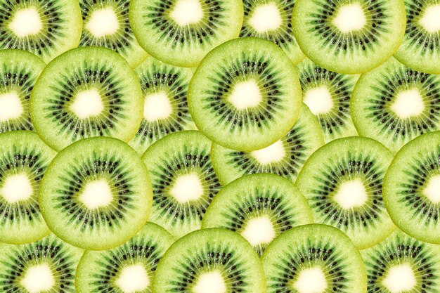 Wzór z kawałków dojrzałego soczystego owocu kiwi Zielone tło