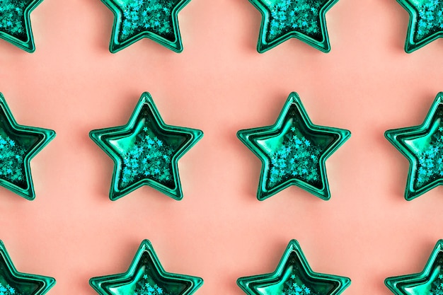 Wzór z pięcioramiennej gwiazdy metalicznej mięty na różowej powierzchni Błyszcząca dekoracja.
