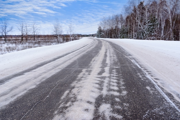 Wzory Na Zimowej Autostradzie W Postaci Czterech Prostych Linii. śnieżna Droga Na Tle Ośnieżonego Lasu. Zimowy Krajobraz.