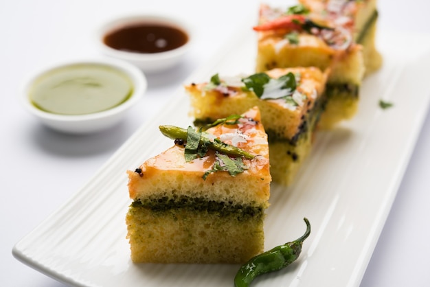 Yellow Sandwich Dhokla to indyjska pikantna przekąska z mąki z ciecierzycy lub mąki ryżowej, pochodząca z Gujarat. Podawany z chutneyem z zielonego i tamaryndowca. selektywne skupienie