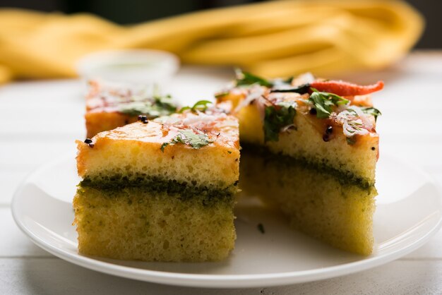 Yellow Sandwich Dhokla to indyjska pikantna przekąska z mąki z ciecierzycy lub mąki ryżowej, pochodząca z Gujarat. Podawany z chutneyem z zielonego i tamaryndowca. selektywne skupienie