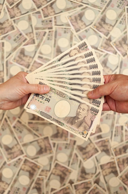 YEN Japońskie pieniądze Trzymając się za ręce, płacąc za otrzymanie banknotu 100 000 jenów