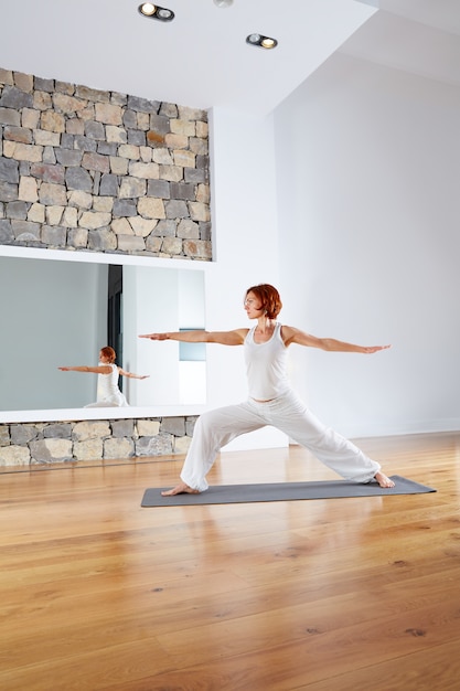 Yoga Warrior two II pose in wooden floor