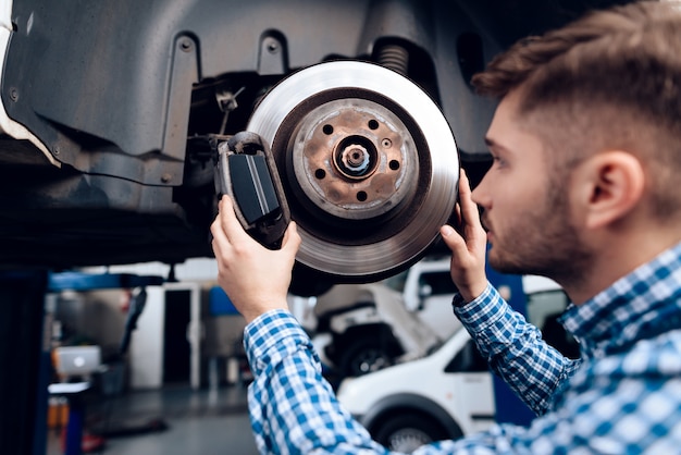 Young Mechanic Repairs Automotive Hub In Garage.