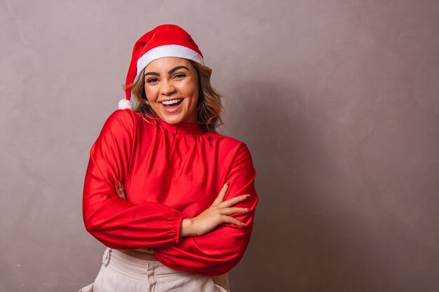 Z bliska strzał pięknej młodej kobiety z santa hat i rękami skrzyżowanymi. Wesołych Świąt