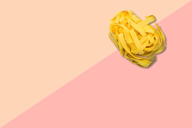 Z bliska włoskie surowe spaghetti izolowane na różowym tle