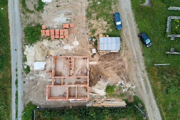 Z góry na dół widok z lotu ptaka prac budowlanych nowego fundamentu betonowego domu na placu budowy.