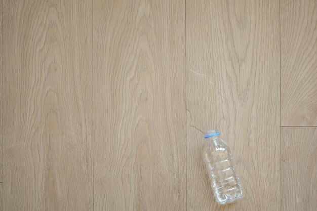 Z góry widok butelki wody rozlanej na podłodze