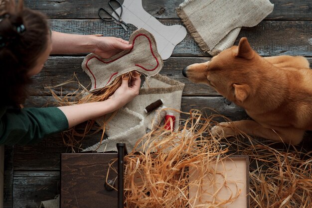 Zdjęcie z góry widok rąk kobiet robiących zabawki dla psów z tekstyliów i wypełniaczy ekologicznych