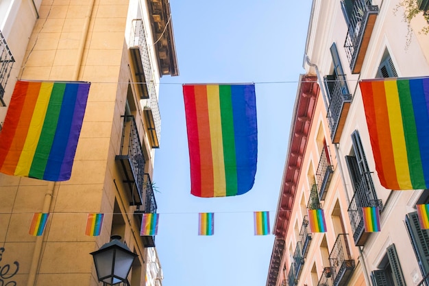 Z niskiego kąta widok kolorowych flag wiszących pośród budynków
