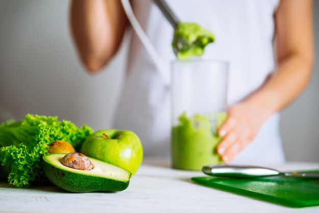 Zdjęcie z przodu składniki smoothie. kobieta co koktajl na tle. koncepcja zdrowej żywności