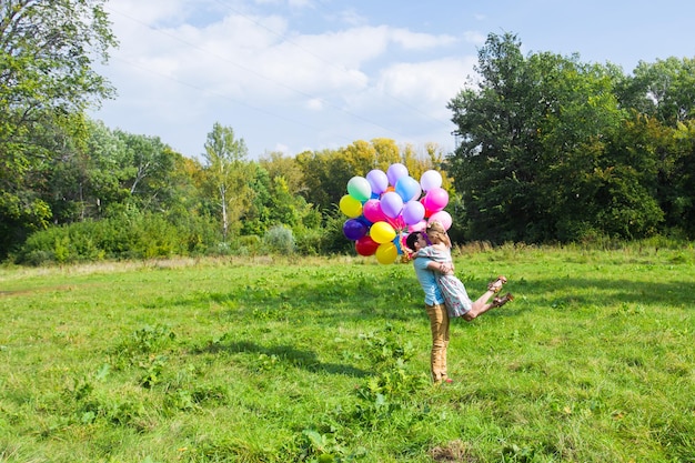 Z tyłu chłopiec bawiący się balonami na boisku