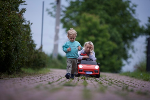 Zdjęcie z tyłu widok chłopca bawiącego się walizką na boisku