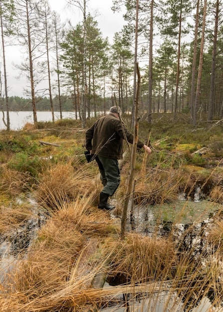 Zdjęcie z tyłu widok człowieka idącego po lesie