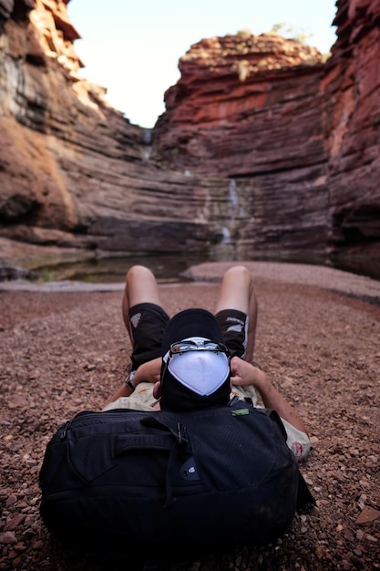Zdjęcie z tyłu widok człowieka leżącego na pustyni na tle formacji skalnych