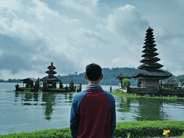 Zdjęcie z tyłu widok człowieka patrzącego na świątynię i jezioro