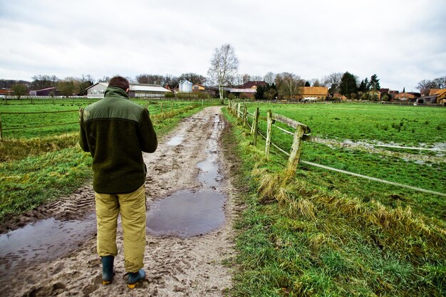 Zdjęcie z tyłu widok człowieka stojącego na farmie