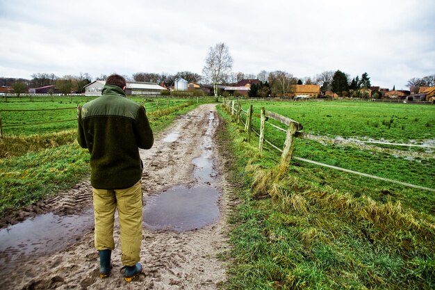 Z tyłu widok człowieka stojącego na farmie