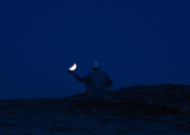 Zdjęcie z tyłu widok człowieka stojącego na tle księżyca na niebie