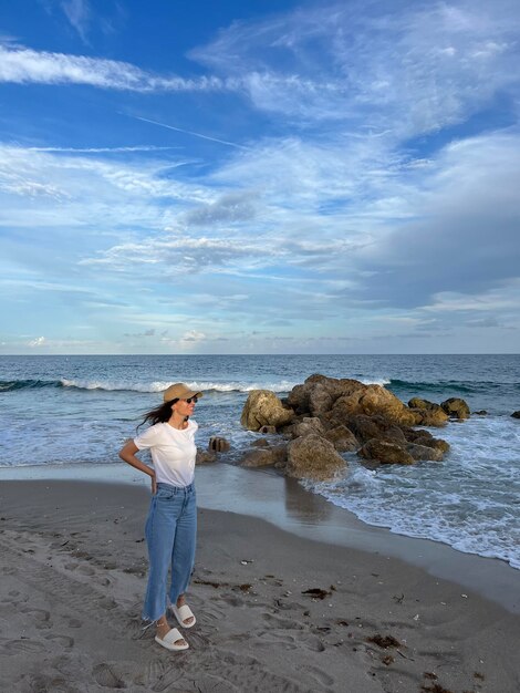 Zdjęcie z tyłu widok kobiety stojącej na plaży na tle nieba