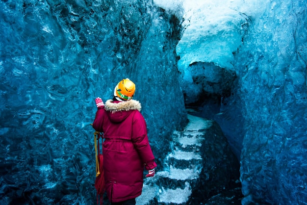 Zdjęcie z tyłu widok kobiety stojącej przy wejściu do jaskini lodowej