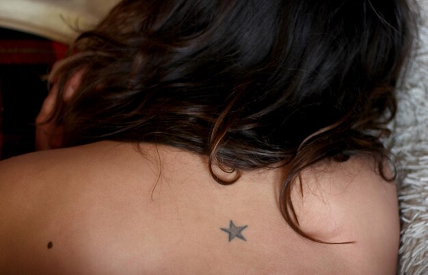 Zdjęcie z tyłu widok kobiety z tatuażem w kształcie gwiazdy na plecach