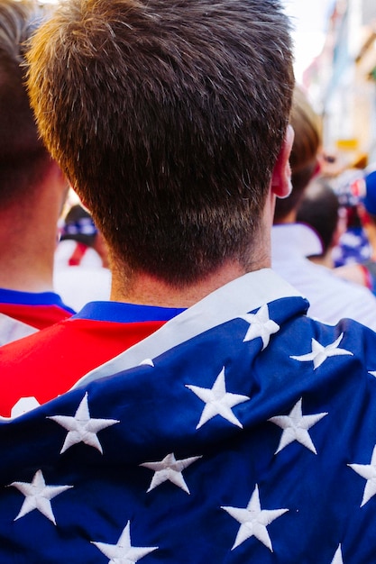 Zdjęcie z tyłu widok mężczyzny z amerykańską flagą na wydarzeniu