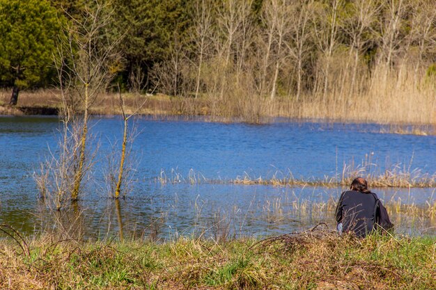 Zdjęcie z tyłu widok mężczyzny z widokiem na spokojne jezioro