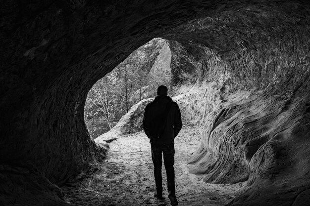 Zdjęcie z tyłu widok sylwetki dorosłego mężczyzny stojącego w jaskini