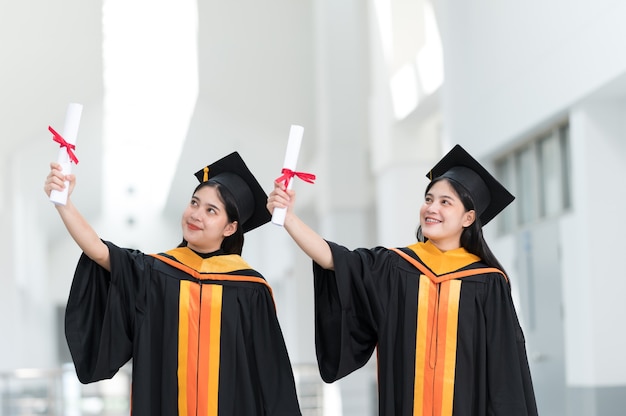 Z tyłu wizerunek kobiet absolwentów college'u ubranych w czarny kapelusz żółty pomponem