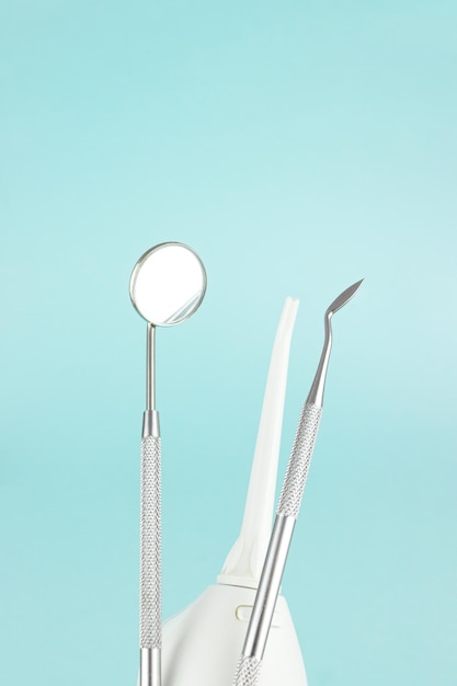 Ząb i instrumenty dentystyczne na niebieskim tle Leczenie dentystyczne Narzędzia dentystyczne lustro Skopiuj miejsce na tekst