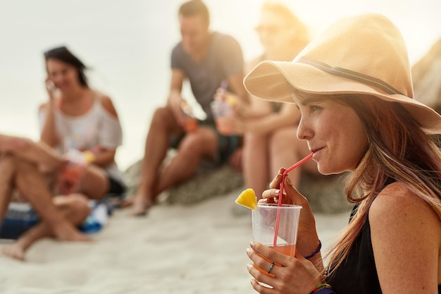 Zabawa gwarantowana, gdy są razem Ujęcie grupy szczęśliwych młodych przyjaciół wspólnie spędzających piknik na plaży