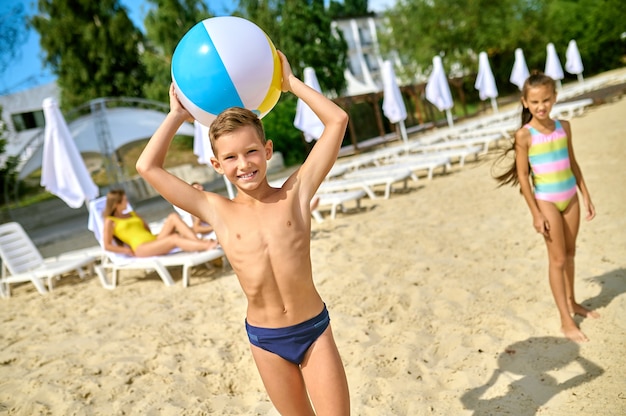 Zabawa na plaży. Dzieci grające w piłkę na plaży