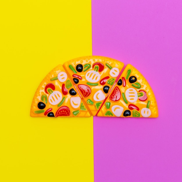 Zdjęcie zabawka pizza na kolorowym tle. fast food flat lay art