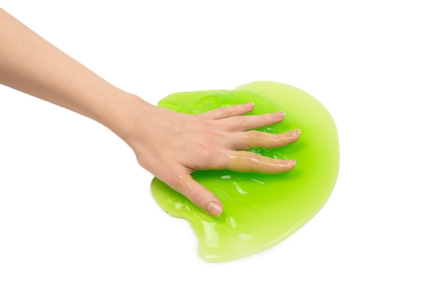 Zabawka zielony szlam w ręce kobiety na białym tle.