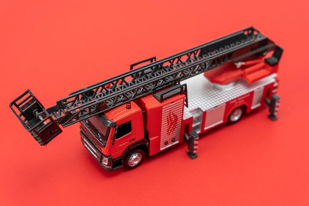 Zabawkarski samochód strażacki na czerwonym tle Pojazd ratunkowy
