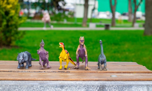 Zdjęcie zabawki dinozaury na ławce w parku zieleń natura wiosna wesołego dnia dino
