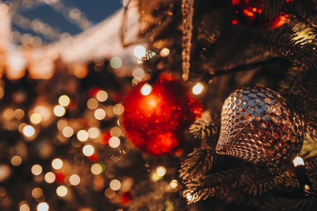 Zabawki świąteczne czerwone złote kule wiszące na choince z rozmytym złotym świątecznym bokeh