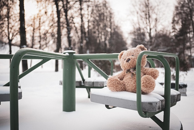 Zdjęcie zabawkowy miś został zimą na placu zabaw