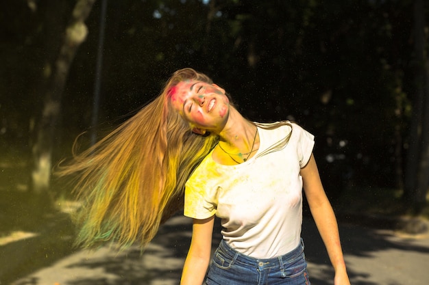 Zabawna blondynka z wiatrem we włosach i żywymi kolorami eksplodującymi wokół niej
