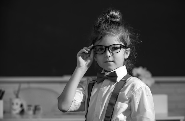 Zabawna dziewczyna-nerd portret dziewczyny w okularach w klasie w domu mała zabawna szkoła